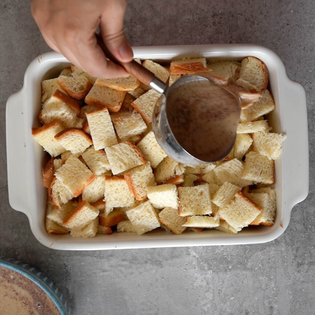 Pouring the custard over the cubed bread