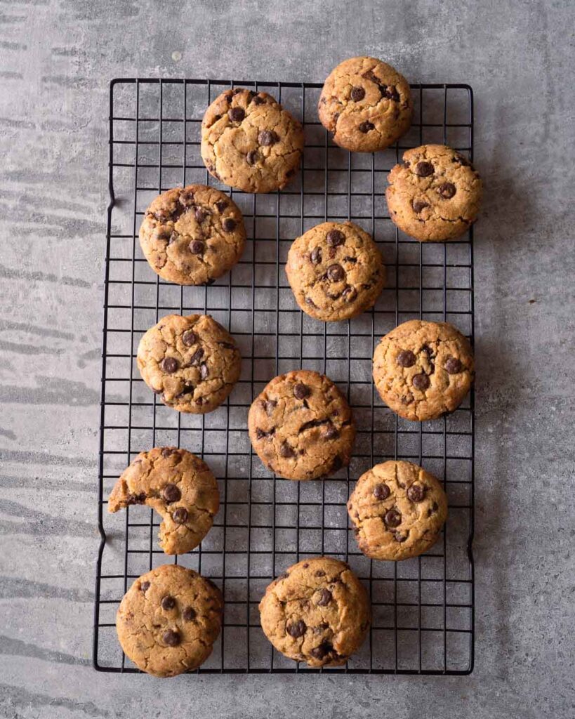 Baked, cooling chocolate chip cookies on a wire rack