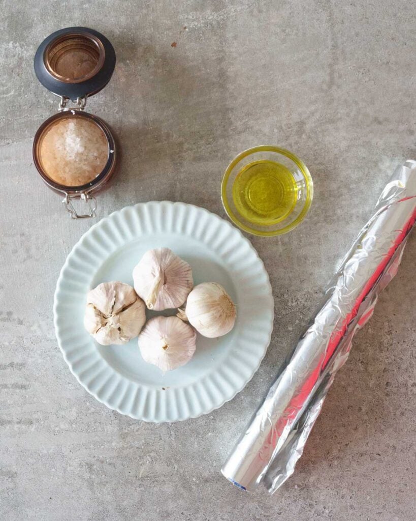 Ingredients to roast garlic in the air fryer- Garlic pods , Olive Oil, Salt & aluminum foil.