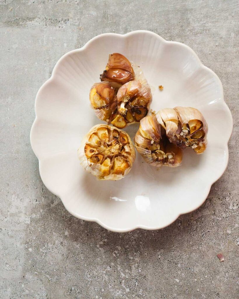 3 Cloves of Roasted Garlic on a white plate