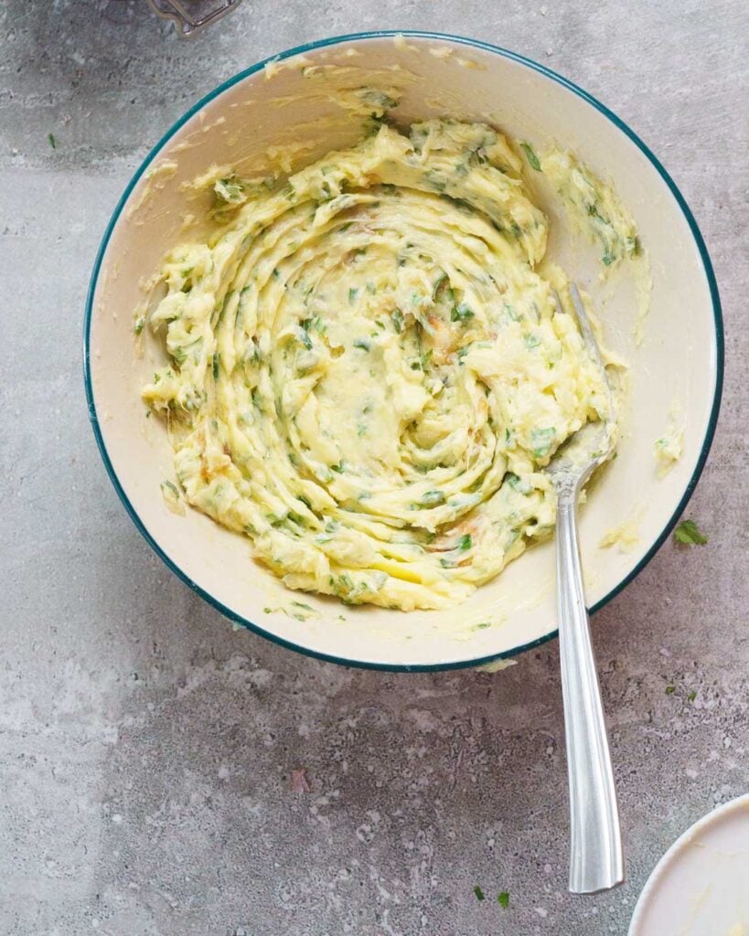 Roasted Garlic Compound butter in a white bowl with a fork