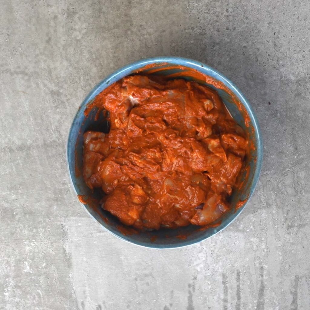 marinating the chicken with the Making goan vindaloo curry paste