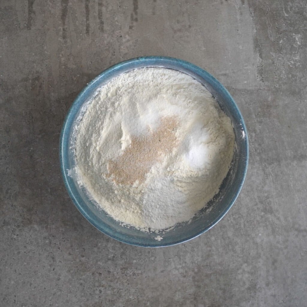flour, yeast,baking powder, baking soda in a blue bowl