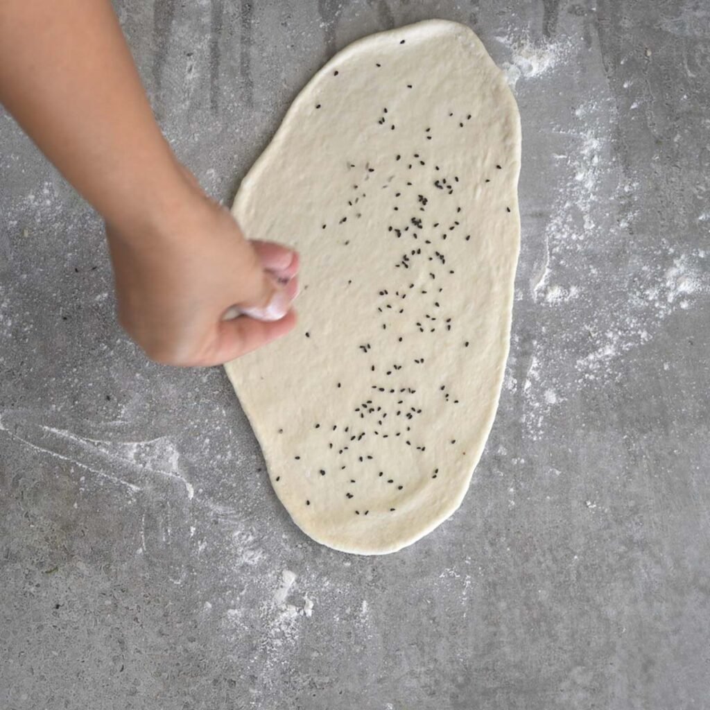 adding black sesame seeds to naan