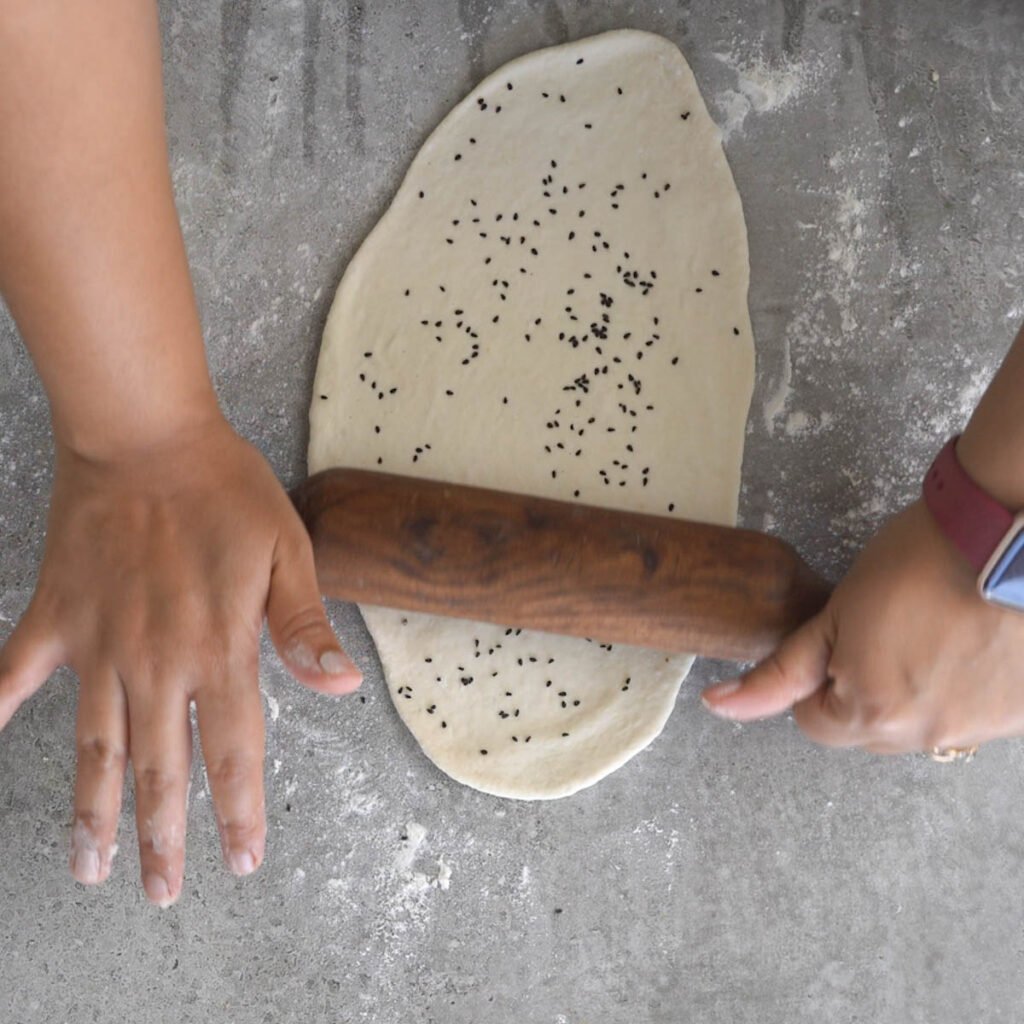 adding black sesame seeds to naan