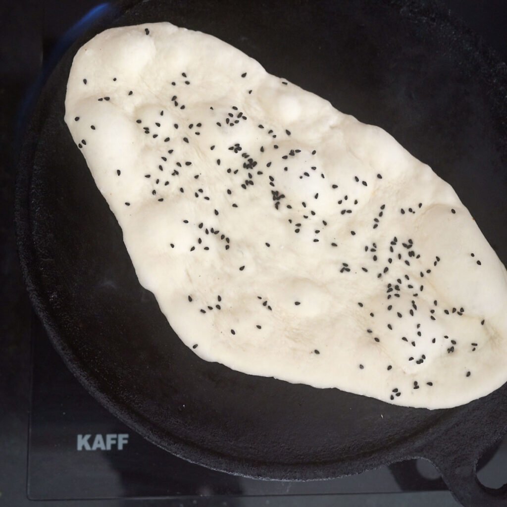 Cooking naan on a cast iron pan or griddle or tawa