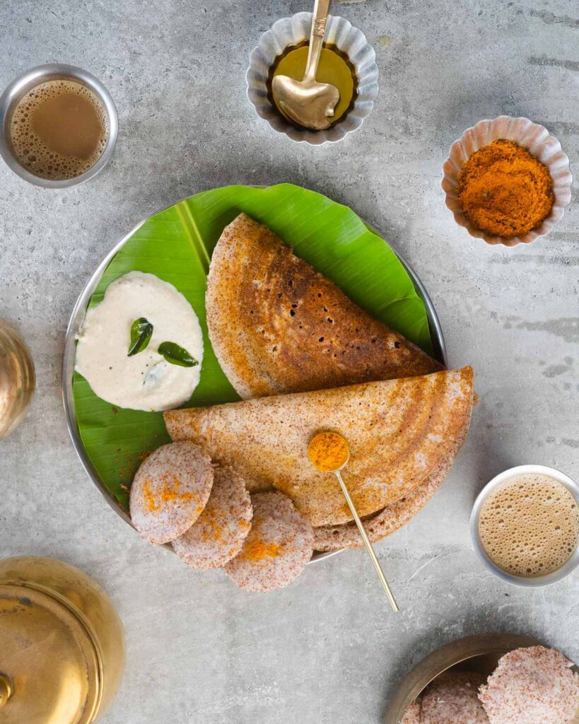 Ragi Dosa and Ragi idli on a plate with banana leaf , served with coconut chutney, Filter coffee and podi.