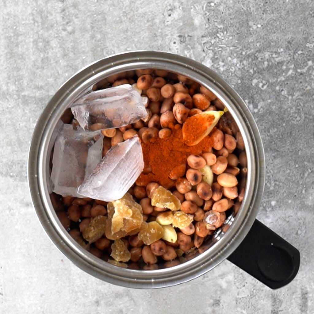 Roasted peanuts, jaggery, chili, salt, water and ice cubes in a blender