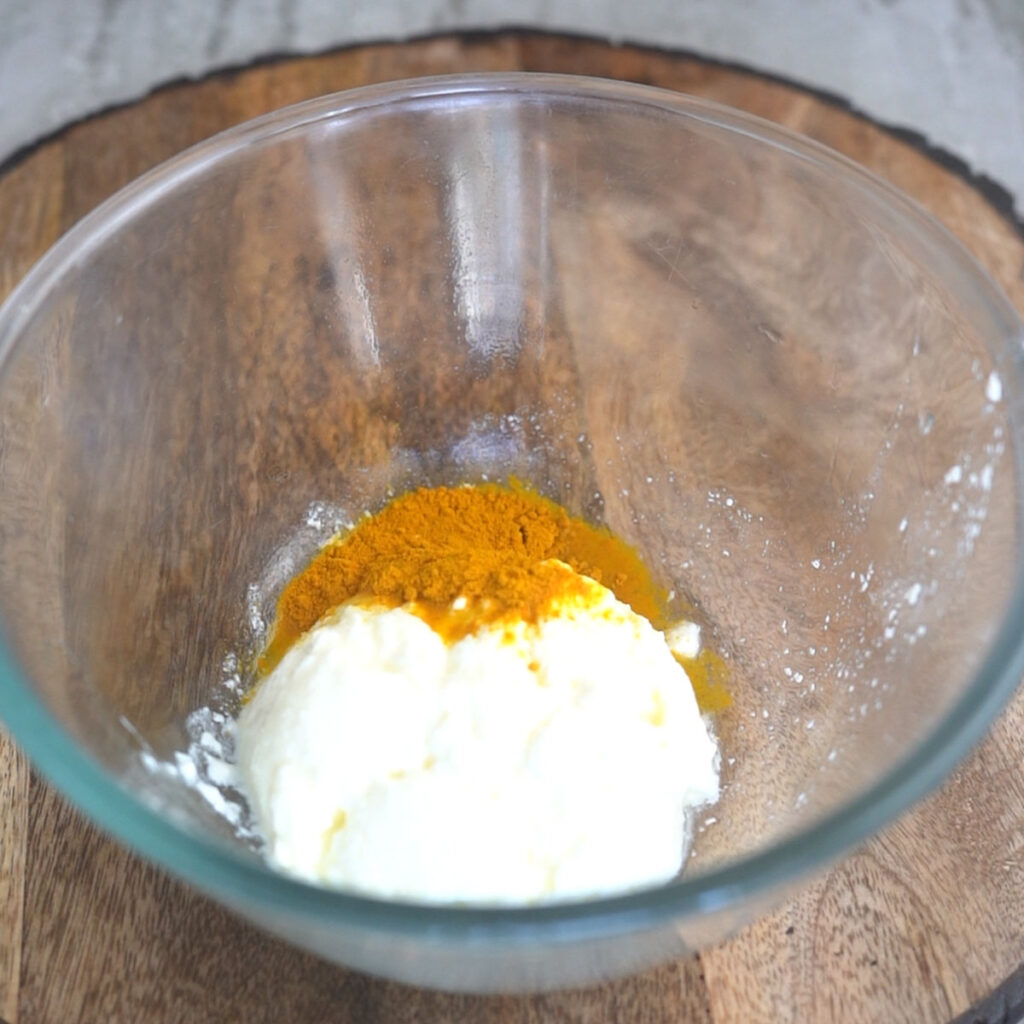 Making the marinade for chicken with yogurt, salt and turmeric