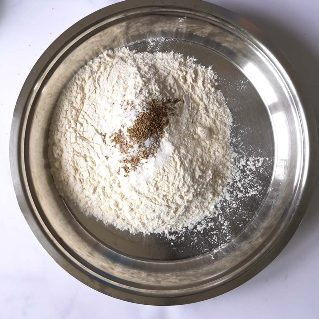 flour, salt and ajwain in a large platter to make bhature dough