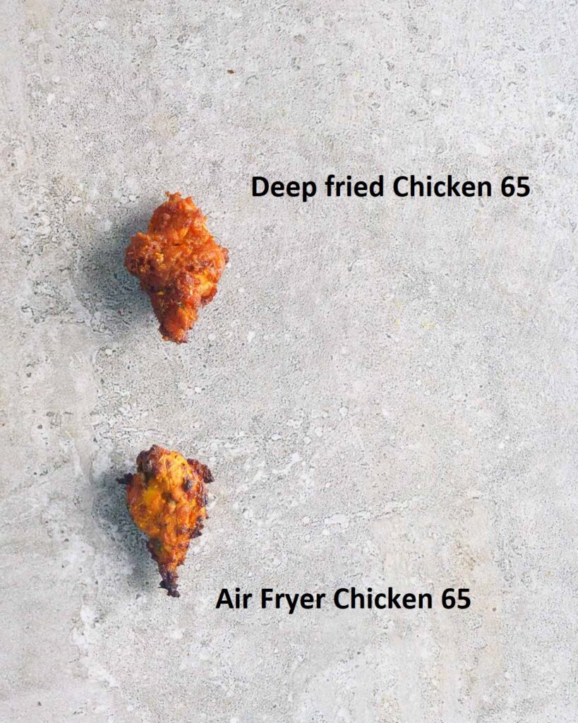 2 pieces of Chicken 65 on a grey background.One has been deep fried and another has been air fried.The air fried chicken 65 is darker and more charred than the deep fried chicken 65