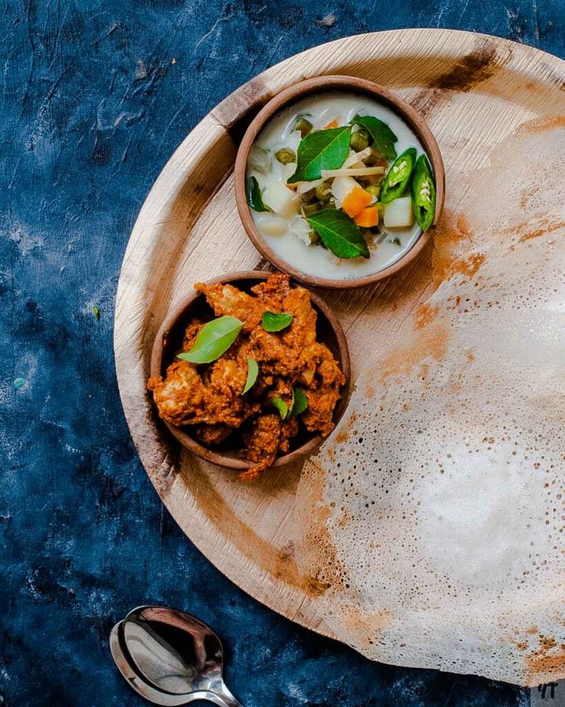 Appam served with vegetable stew and chicken curry