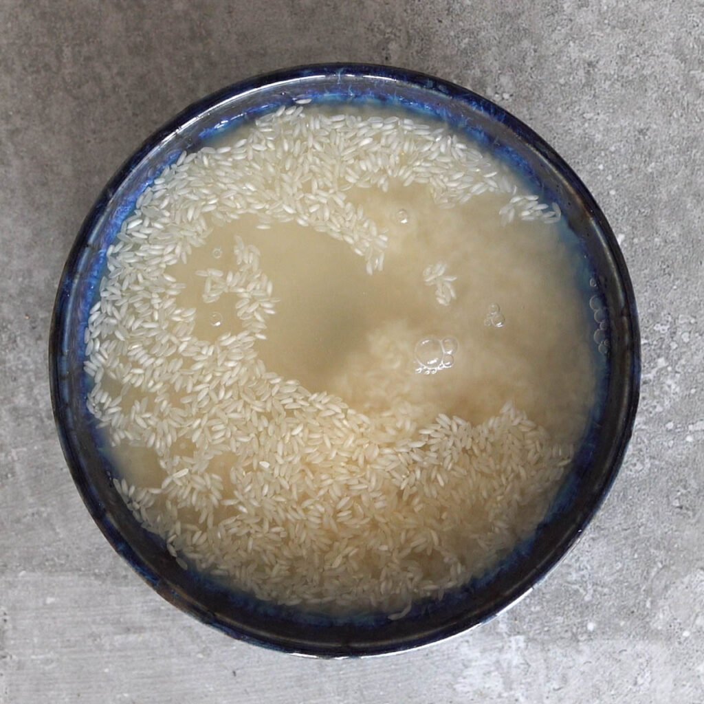 Soaking short grain rice in a blue bowl