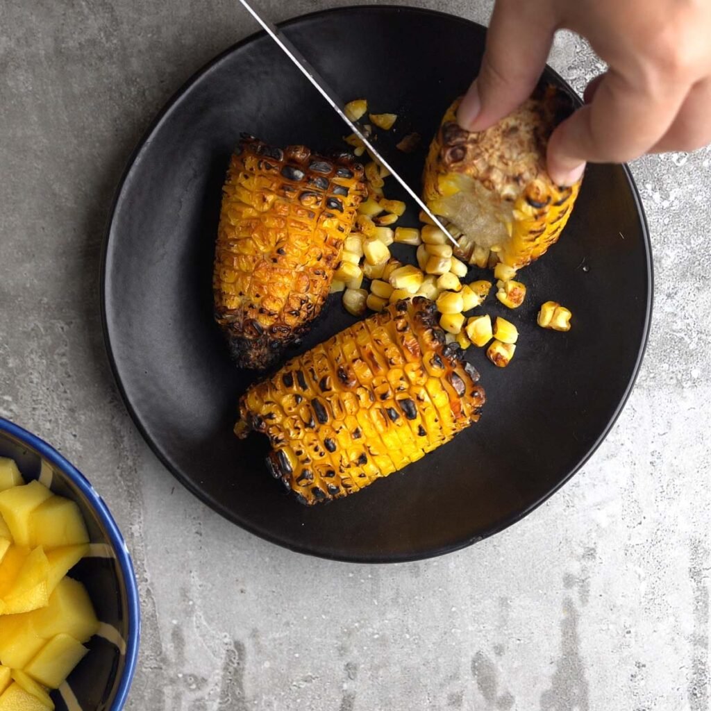 Cutting the corn off the cob using a knife