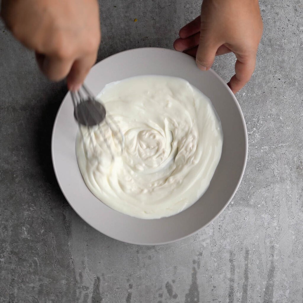 Whisking the mayonnaise and yogurt