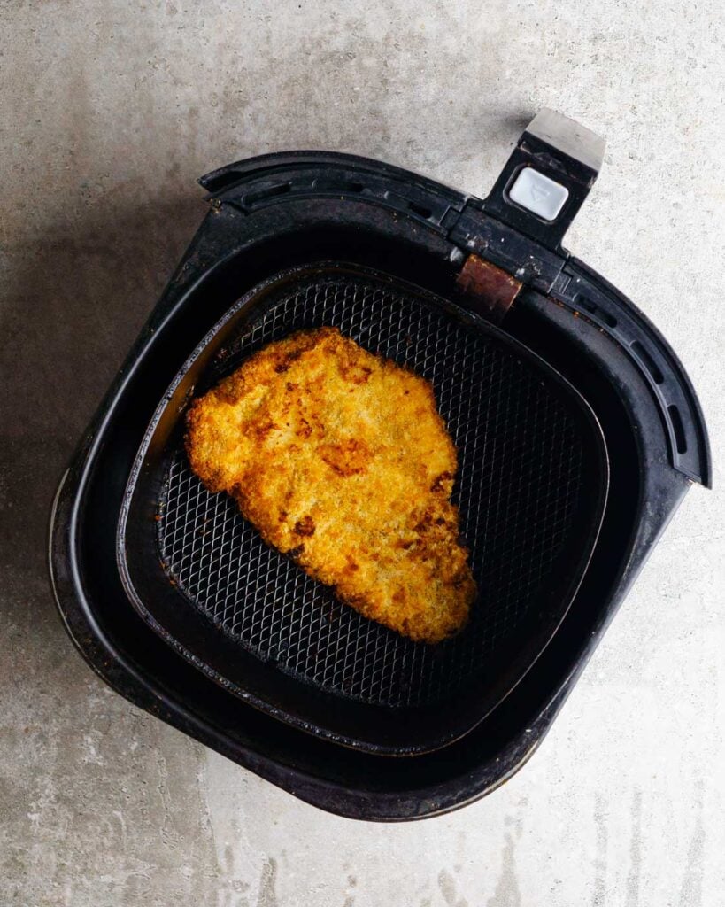 Air fryer Chicken Katsu in the air fryer basket.