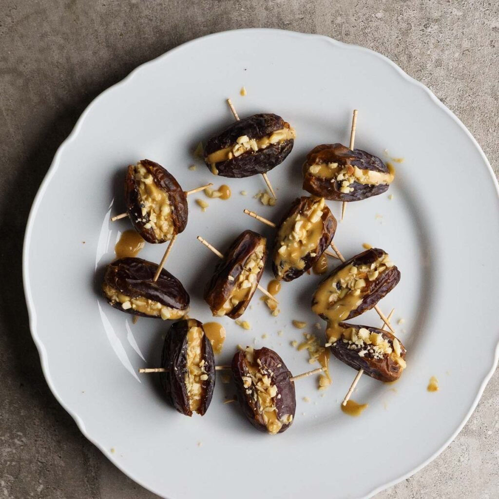 Peanut butter & crushed peanuts stuffed dates, skewered with a toothpick.