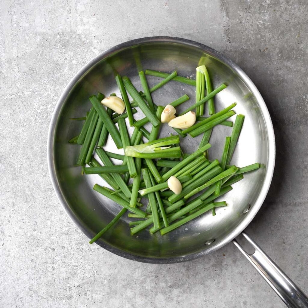 fresh green onions and garlic in a pan