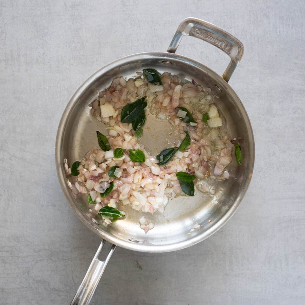 Cuisinart steel pan with cooked onion and curry leaves