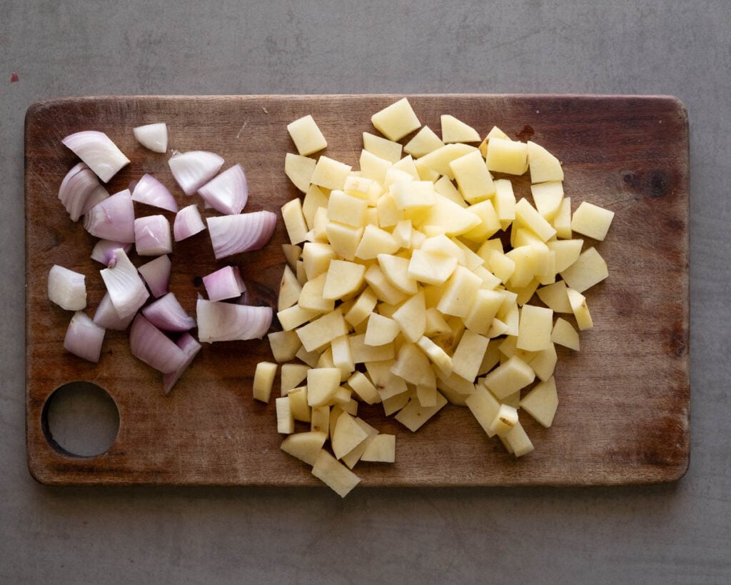 sliced potatoes and onions on a cutting board