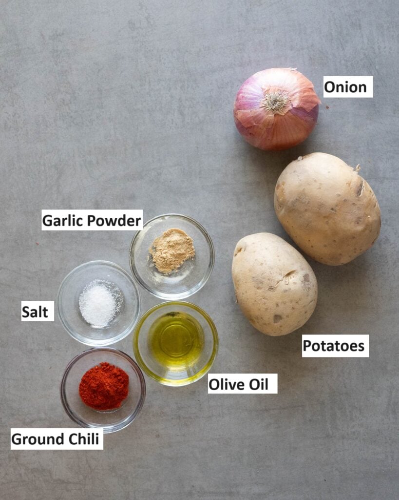 ingredients needed to make crispy air fryer potatoes and onions-  oil, salt, chili, garlic powder, potatoes and onions