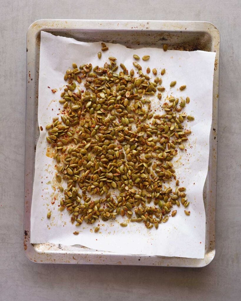 Roasted chili lime pepitas on a baking tray lined with parchment paper