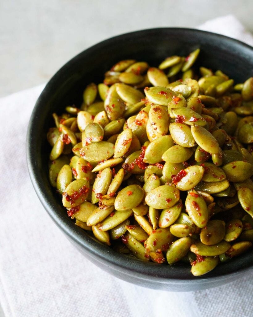 A black bowl filled with roasted chili lime pepitas