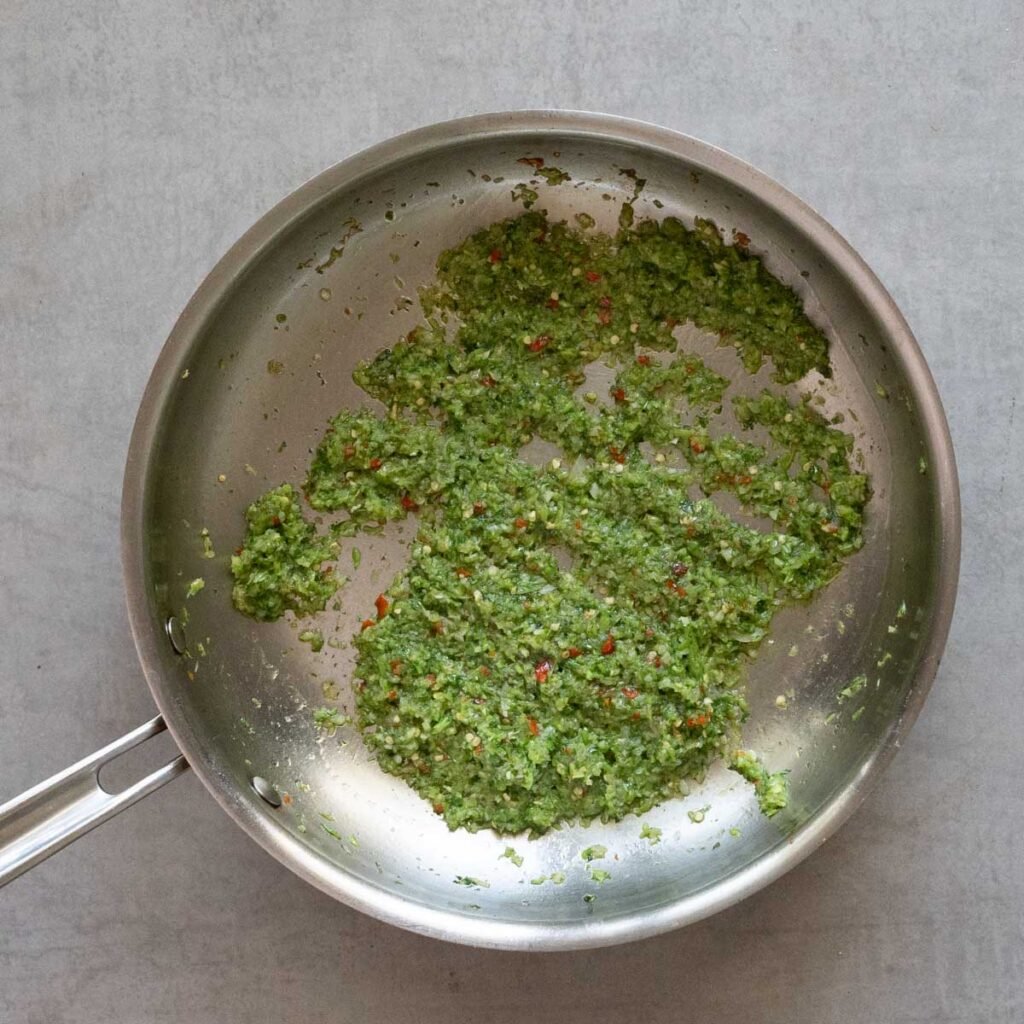Sauteing paste made of chili, cilantro, garlic and shallots in a stainless steel pan