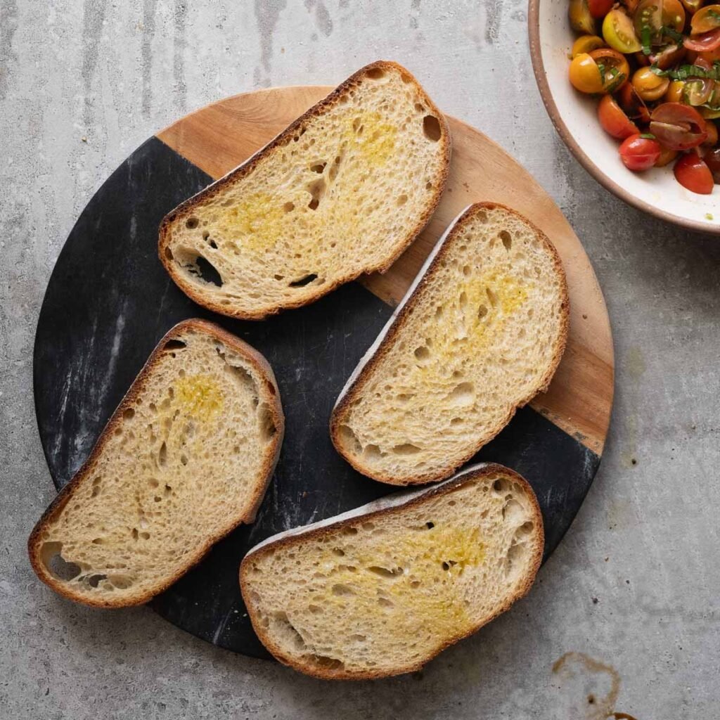 four slices of sour dough bread on a marvle cutting board