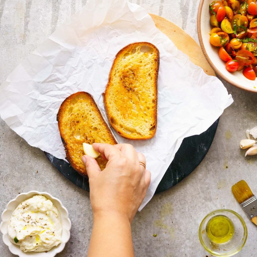 Rubbing clove of garlic on toast