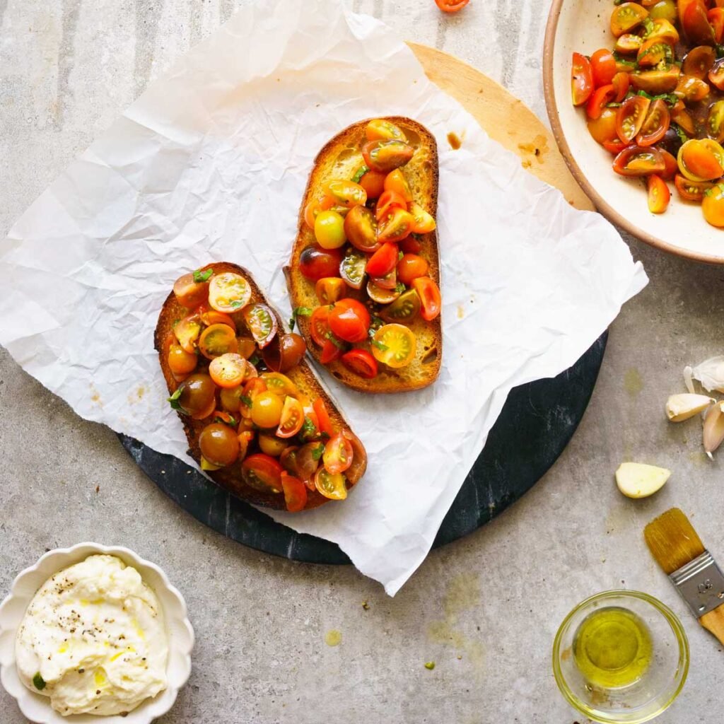 two sour dough bread toasts, topped with marinated tomatoes