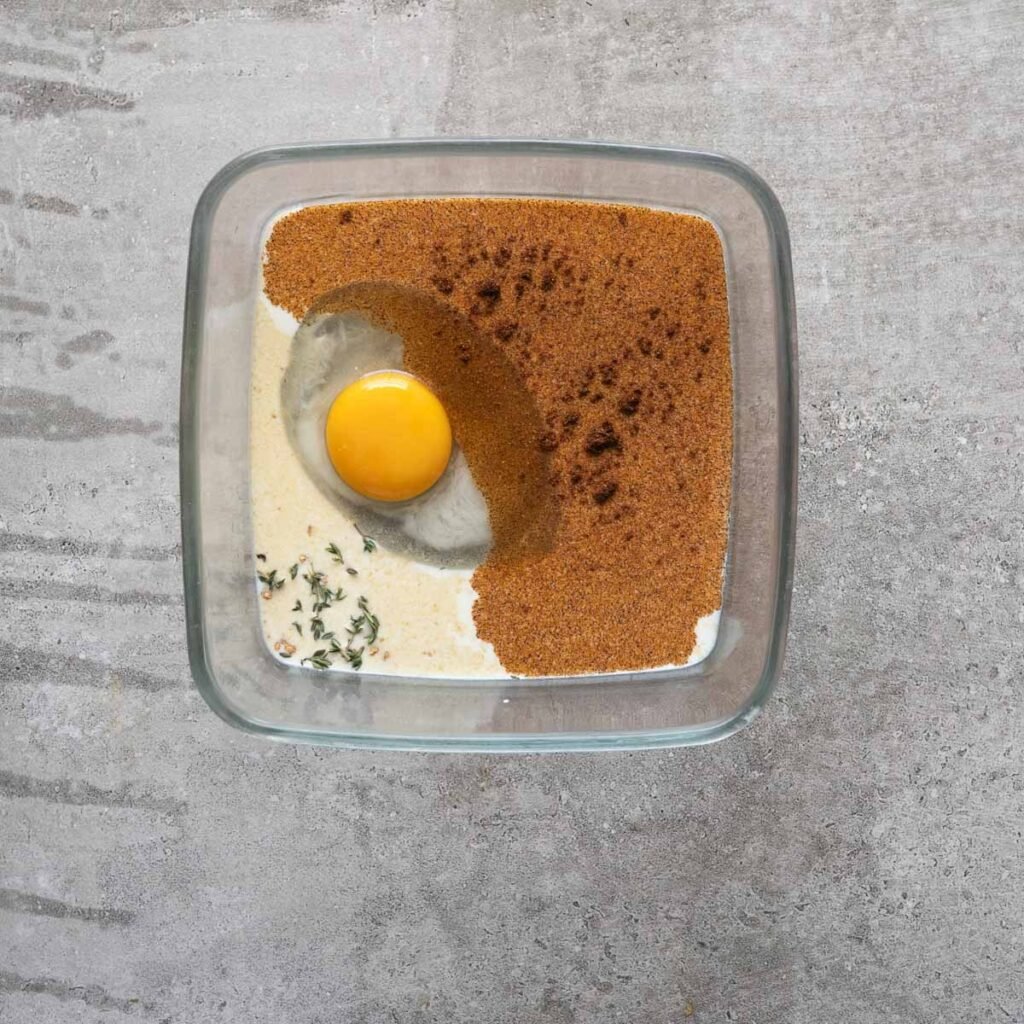 Milk, Egg, garlic powder, paprika and herbs in a shallow square dish.