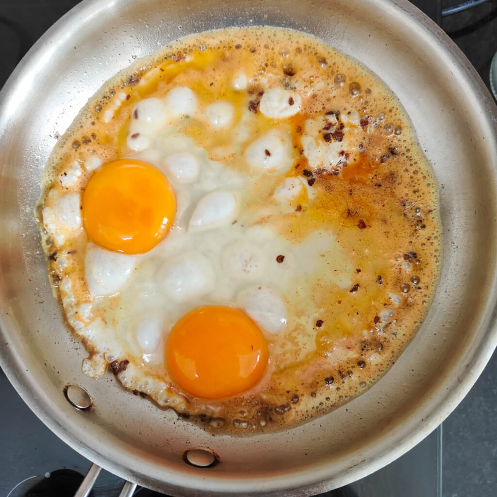 Two eggs broken in a hot pan.