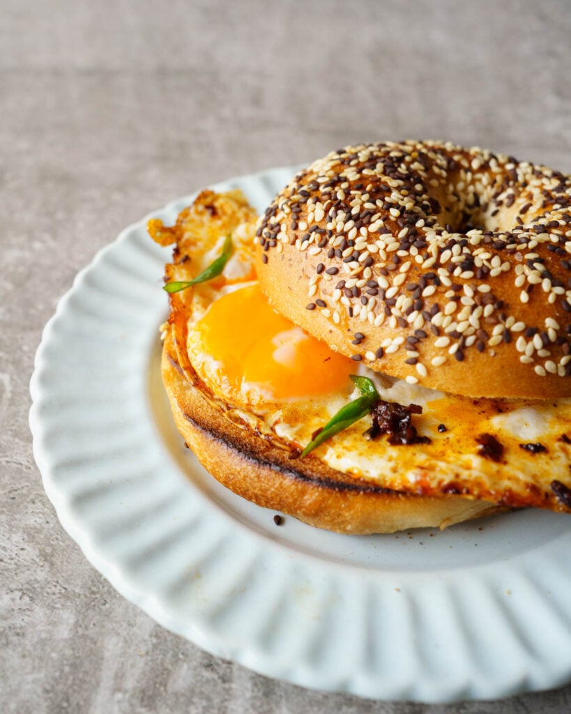 Fried crispy chili oil eggs inside a warm bagel