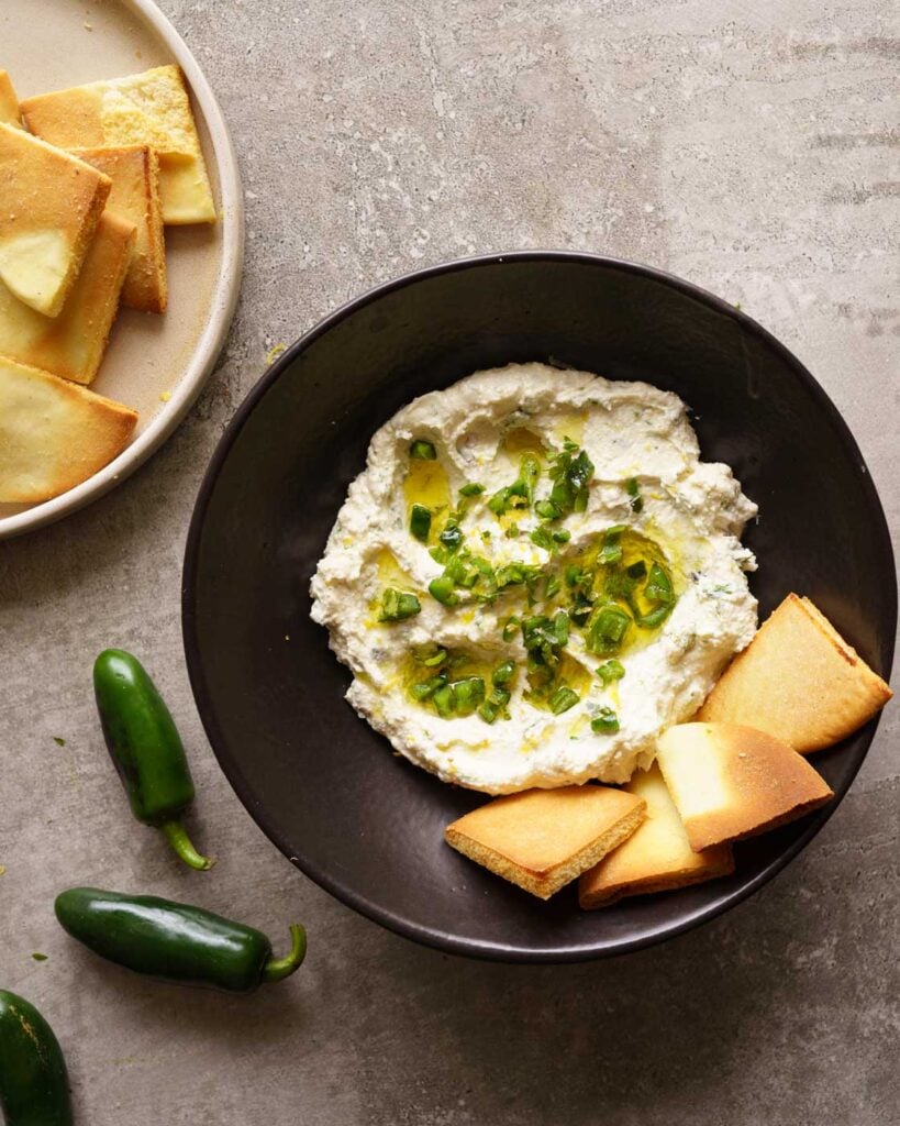 Crazy feta or spicy feta dip with chopped jalapenos on top, served with pita chips