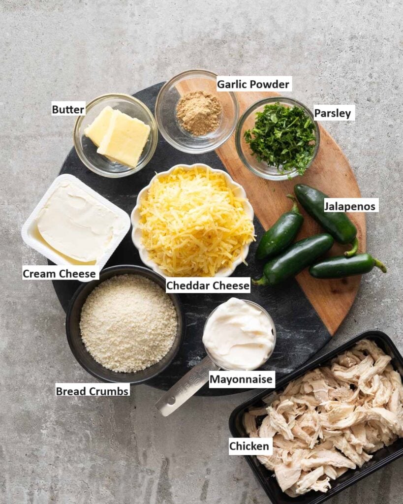 Ingredients needed to make jalapeno chicken popper dip-  cooked shredded chicken , cheddar cheese, cream cheese, butter, garlic powder, parsley, fresh jalapenos and cream cheese