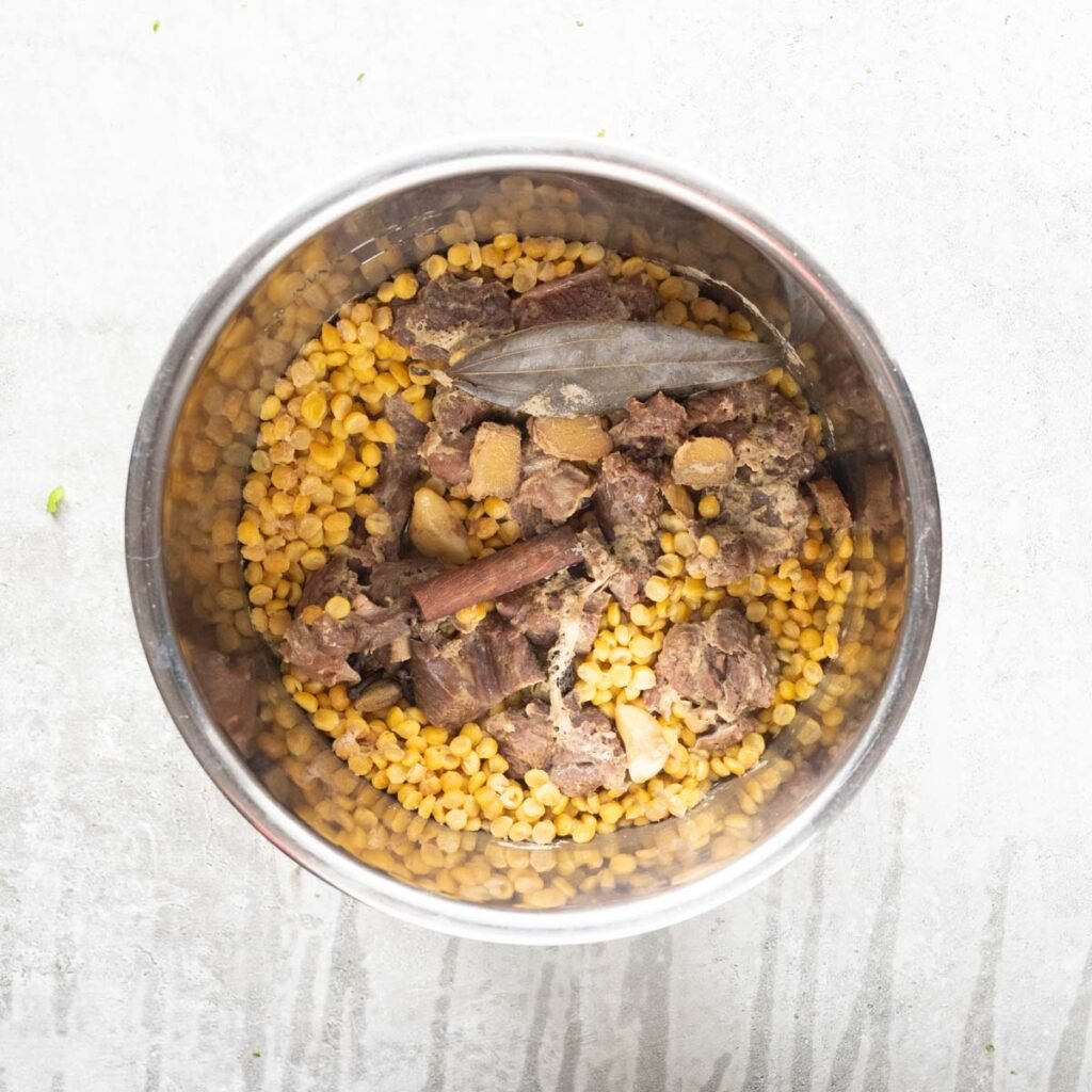 Pressure cooked Mutton, ginger, whole spices, garlic and chana dal in a large bowl