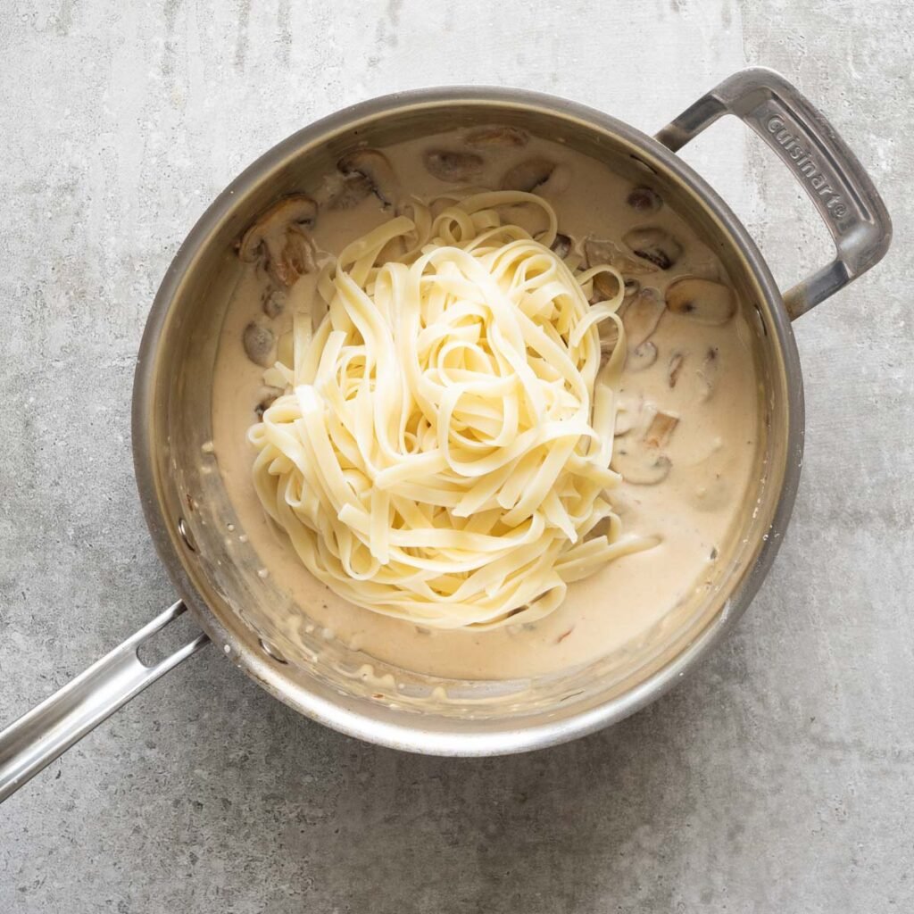 cooked fettucini pasta in a stainless steel pan